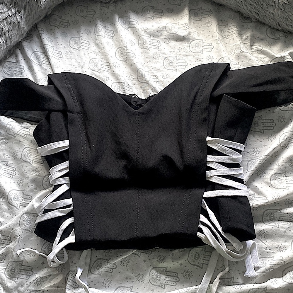 Black corset top with sleeves that sit on the side of your shoulders,